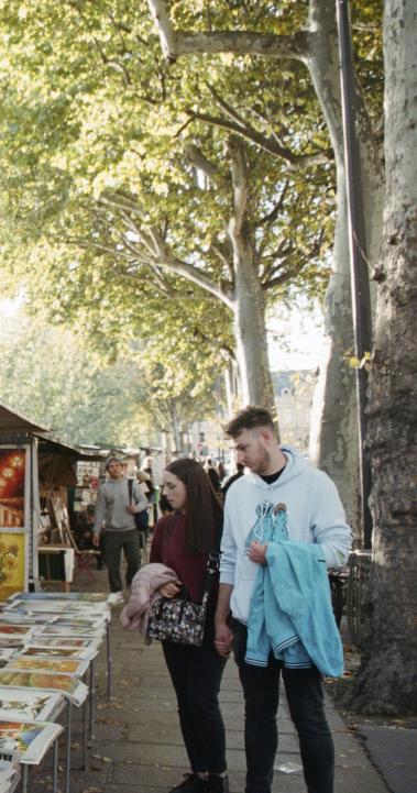 Students check out items at a street vendor in Paris, France.