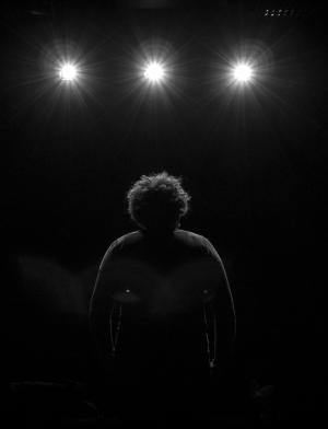 Dublin student standing on stage facing the spotlights