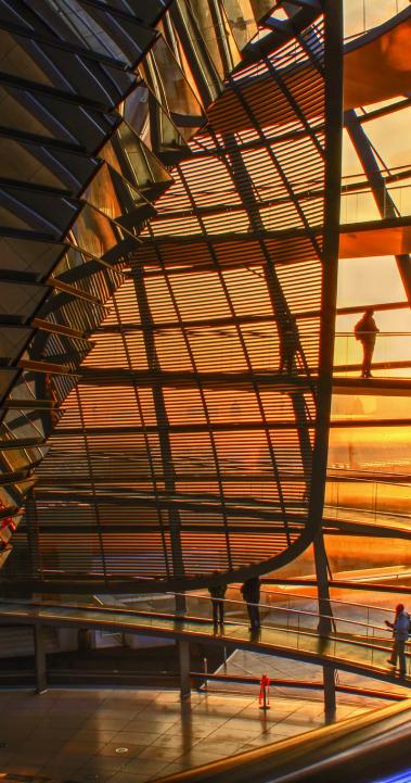 people walking in the dome atop the Reichstag building during sunset