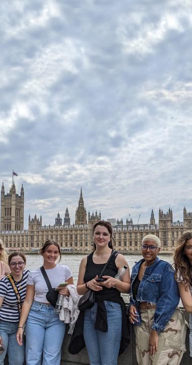 A group of students posing for a photo in front of British Parliament and the River Thames