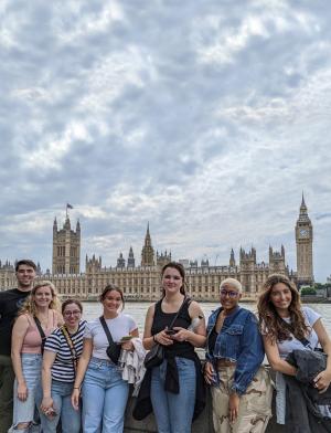 A group of students posing for a photo in front of British Parliament and the River Thames