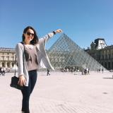 Student at an angle that looks like she is touching the top of the Louvre 