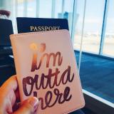 Student holds a passport in a case that reads 