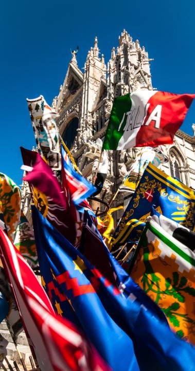 Flags for sale in front of the Duomo di Siena